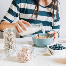 Woman pouring milk on cereals