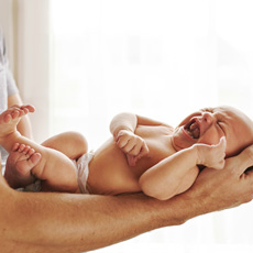 Newborn baby boy being held by his father 